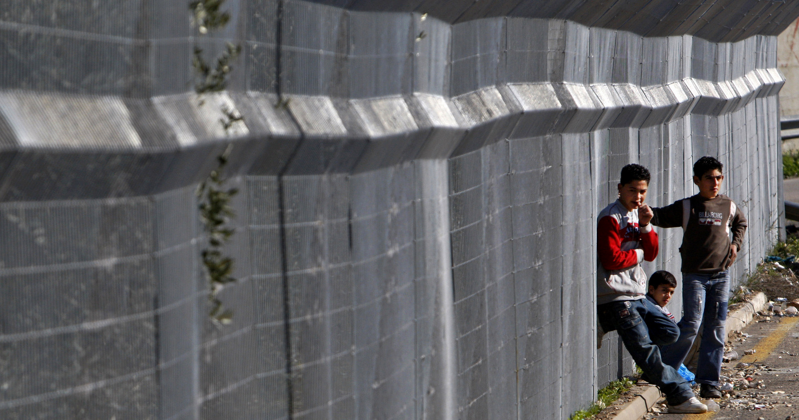 A group of Palestinian boys near a section of Israel's separation barrier at highway 443 near the West Bank village of Beit Urr, Jan. 11, 2008. (AP/Kevin Frayer)