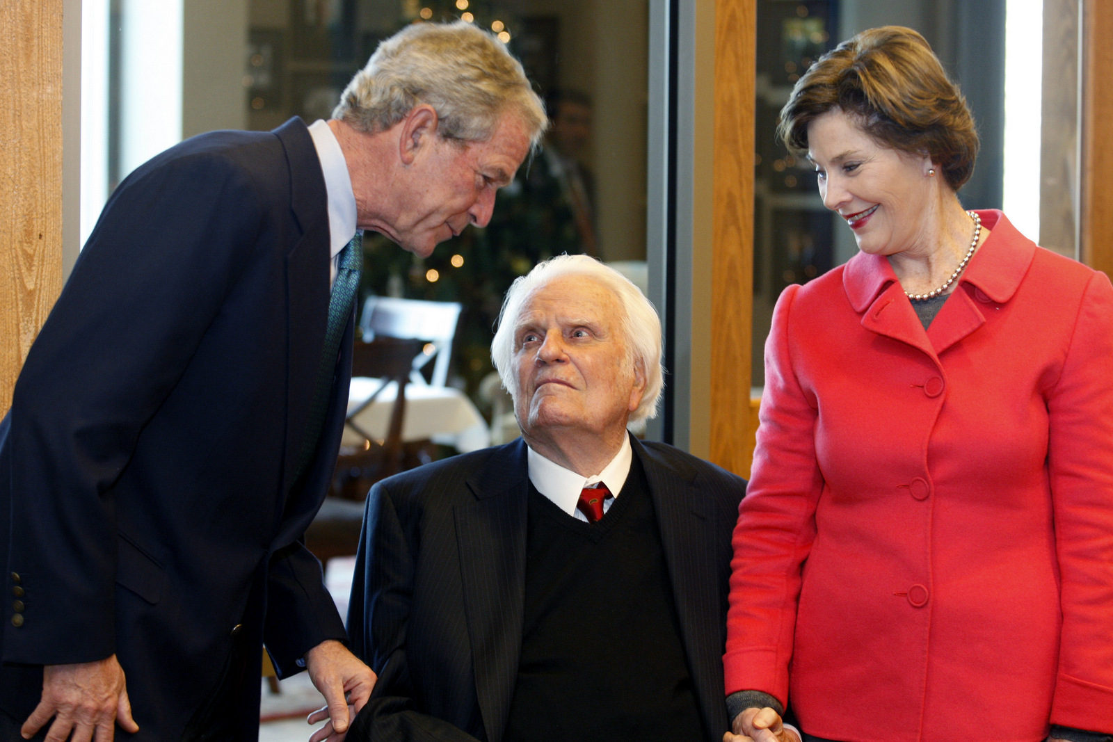 Former President George W. Bush, left, greets evangelist Billy Graham as Laura Bush looks on as they met for a brunch prior to a book signing at the Billy Graham Library in Charlotte, N.C., on Dec. 20, 2010. (AP/Nell Redmond)