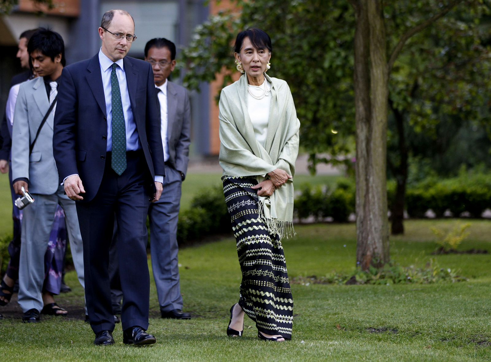 Myanmar opposition leader Aung San Suu Kyi, center, walks with Andrew Dilnot, left, the Principal of St Hugh’s College of the Oxford University as she arrives at a reception in Oxford, England, June 19, 2012. (AP/Lefteris Pitarakis)