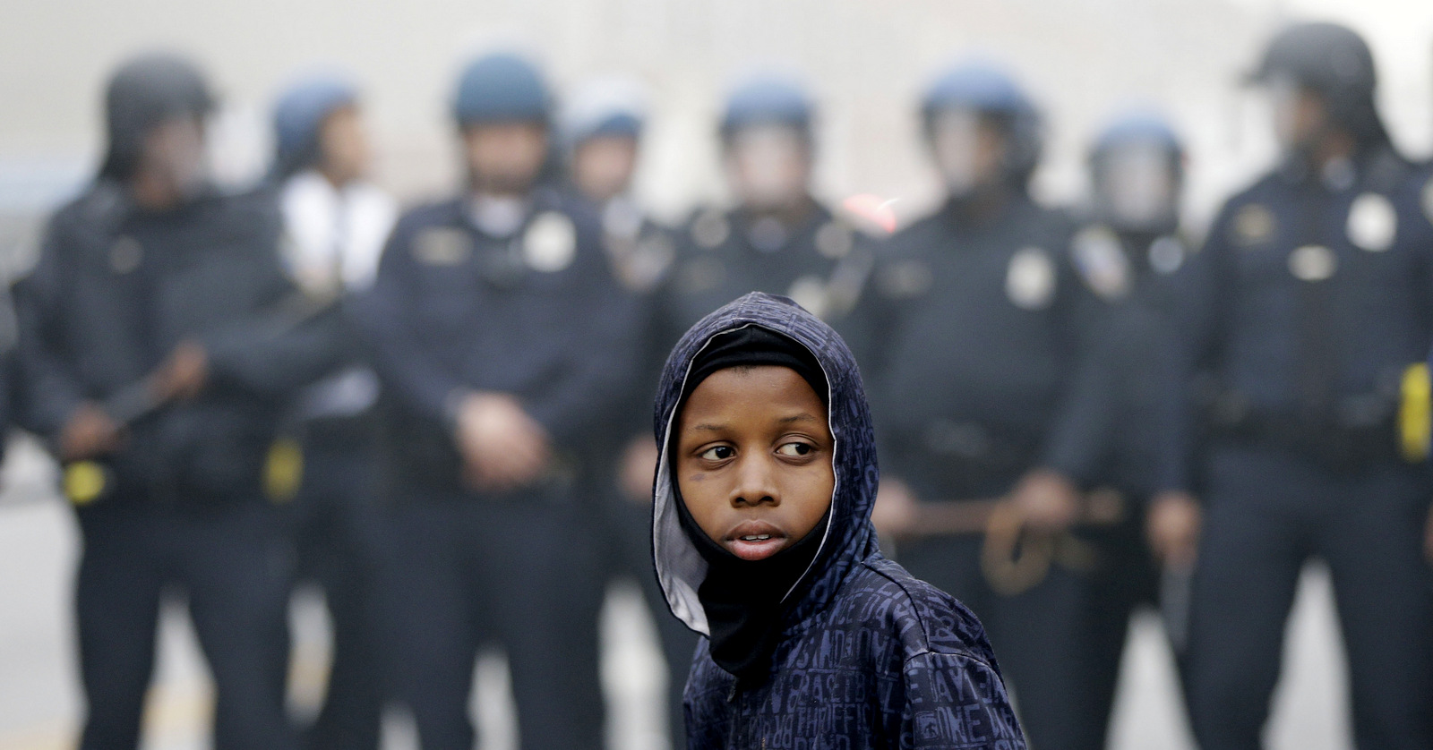A boy stands in front of a police cordon following the funeral of Freddie Gray in Baltimore. Gray's family agreed to a $6.4 million settlement with the city in September 2015. (AP/Matt Rourke)