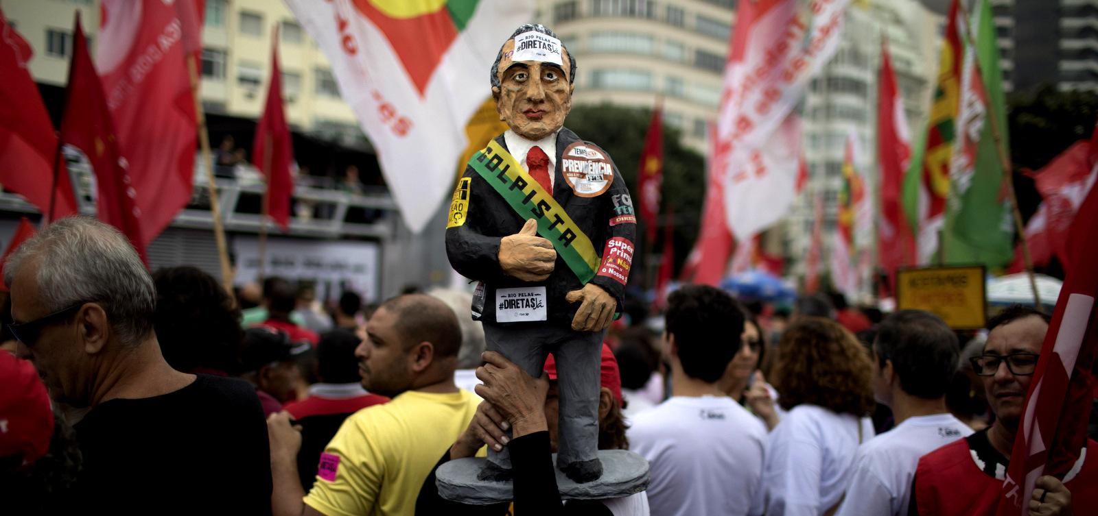A demonstrator carries a statue in the likeness of Brazil's president Michel Temer during a protest against Brazil's president Michel Temer at Copacabana beach in Rio de Janeiro, Brazil, May 28, 2017. People gathered on Copacabana beach ahead of a concert by Brazilian musical performers calling for new presidential elections while pressure mounts on the country's leader to resign amid corruption allegations. (AP/Leo Correa)