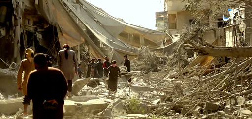 People inspect damage from US coalition airstrikes and artillery shelling in the northern Syrian city of Raqqa, Syria, May 29, 2017. (Aamaq via AP)