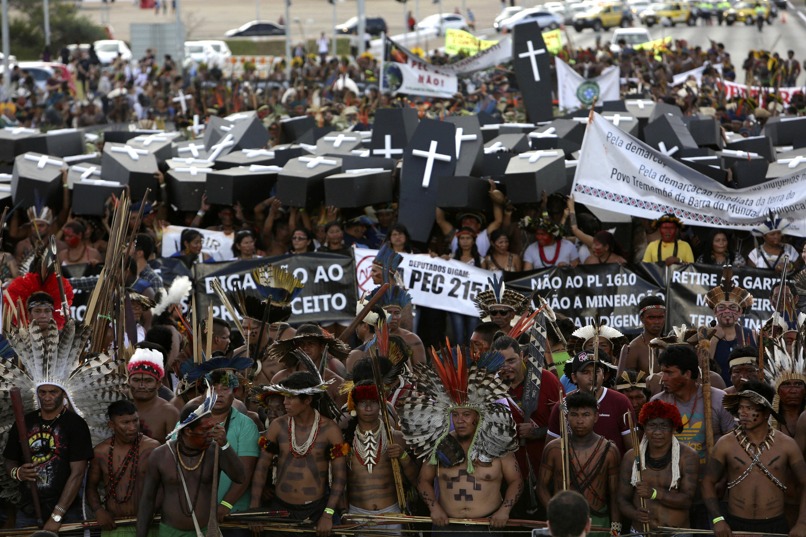 Indigenous protesters from various ethnic groups carry coffins representing indians killed over the demarcation of land, as they demand the demarcation of indigenous lands, outside the National Congress in Brasilia, Brazil. In May, Congress passed two measures that convert around 1.4 million acres of protected land, the vast majority of it in the Amazon, into areas open to logging, mining and agricultural use. (AP/Eraldo Peres)