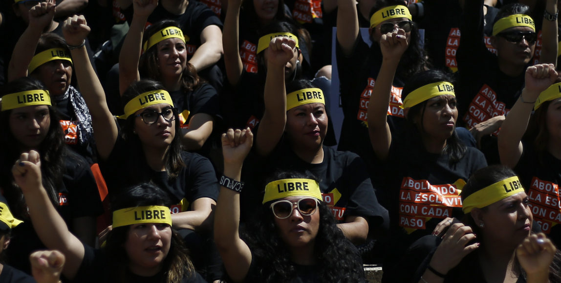 People protesting against human trafficking and slavery raise their fists during a demonstration in Mexico City, Oct. 14, 2017. (AP/Marco Ugarte)