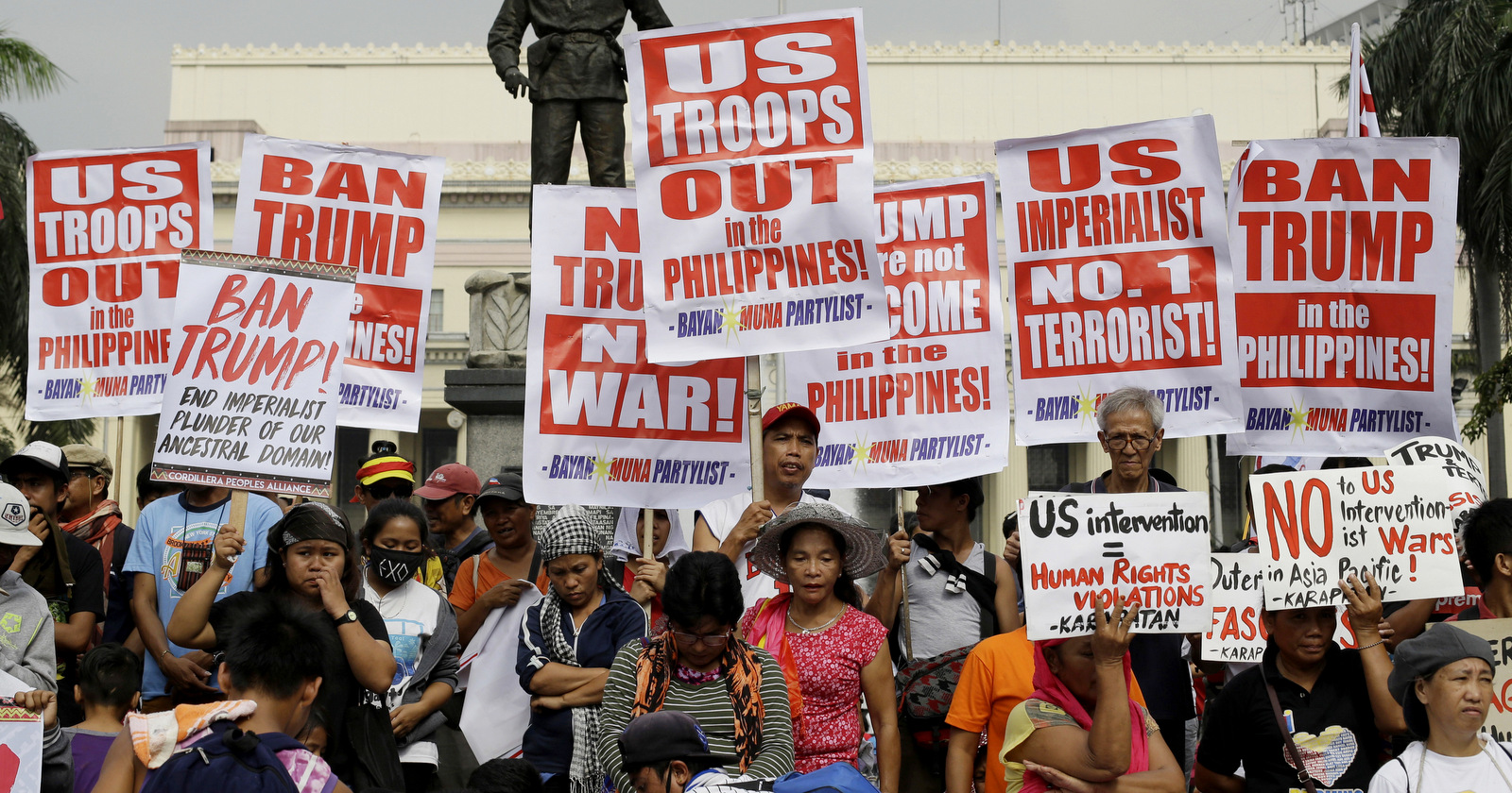 Demonstrators hold slogans during a rally to protest the visit of U.S. President Donald Trump as well as the 31st ASEAN Summit and Related Summits, Nov. 14, 2017 in Manila, Philippines. (AP/Aaron Favila)