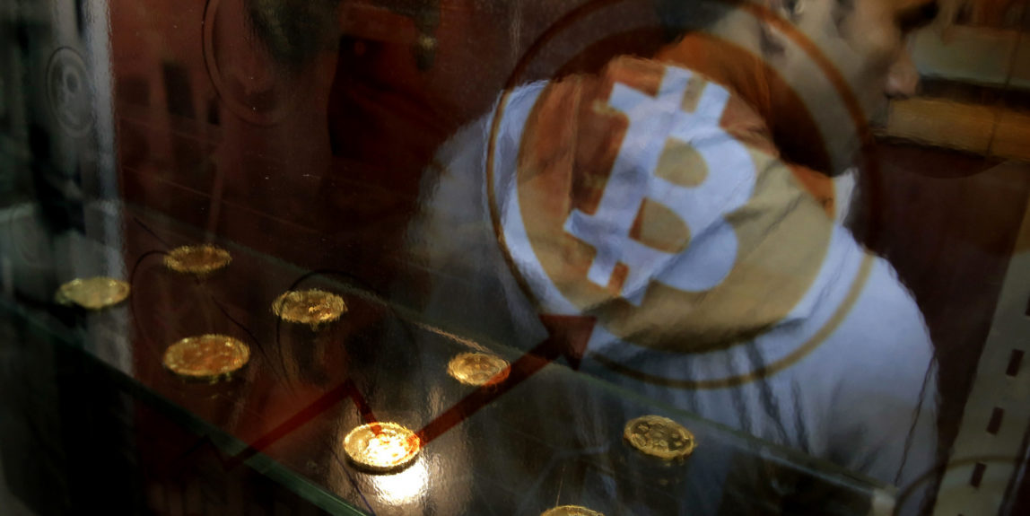 In this Friday, Dec. 8, 2017, file photo, a man uses a Bitcoin ATM in Hong Kong. Bitcoin is the world's most popular virtual currency, but multitudes of alternatives are springing up around the world. (AP/Kin Cheung)