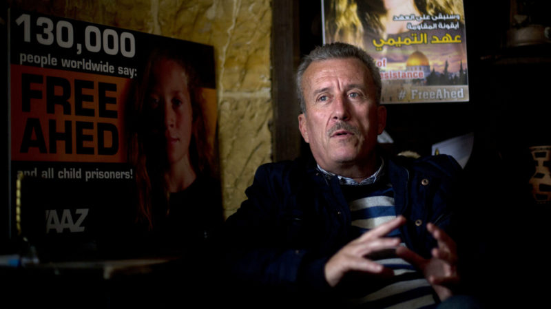 Bassem Tamimi speaks in front of a poster showing his daughter Ahed at his home in Nabi Saleh near the West Bank city of Ramallah. Israel's hard-charging prosecution of his 16-year-old daughter who slapped two Israeli soldiers has trained a spotlight on her family and its role in near-weekly protests against Israeli occupation staged in several West Bank cities. (AP/Majdi Mohammed)