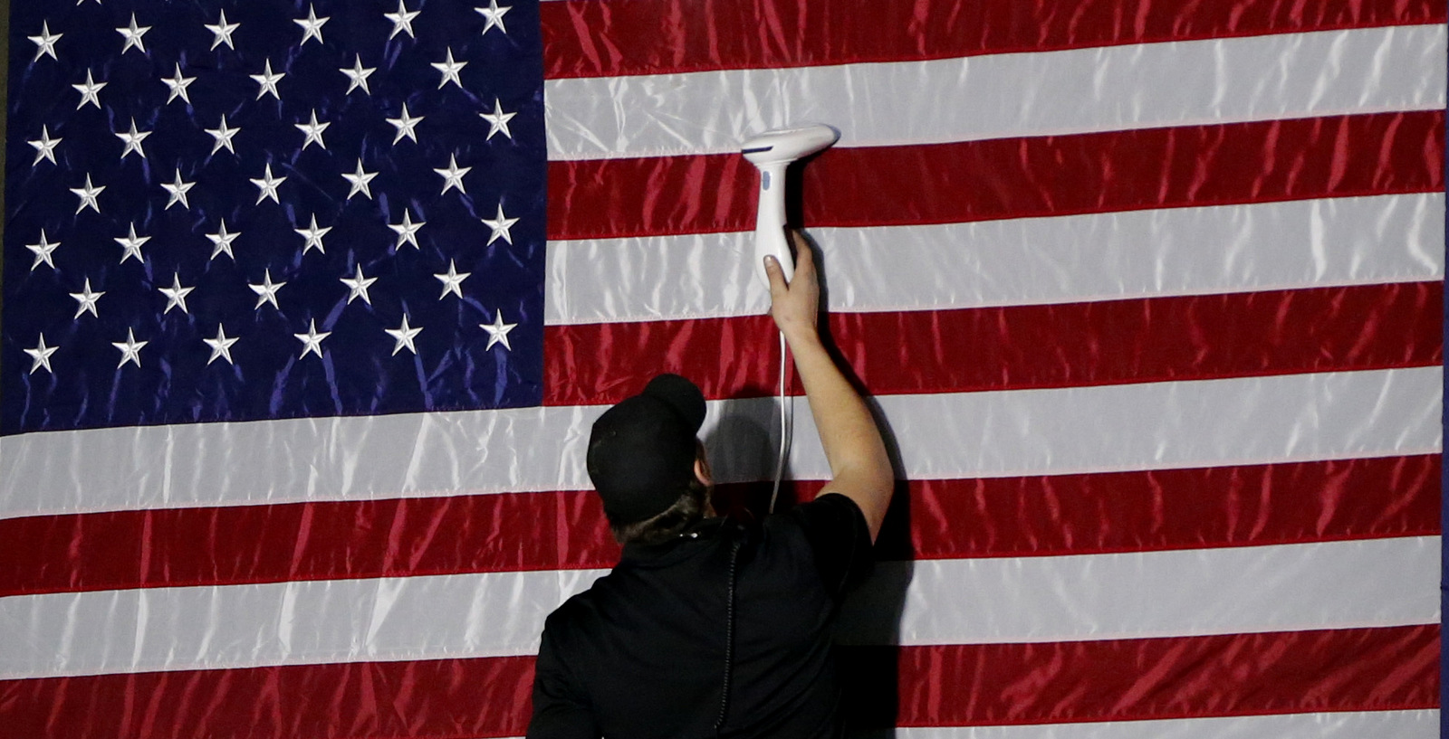 A worker steams out wrinkles on an American flag before President Donald Trump arrives to speak at H&K Equipment, Jan. 18, 2018 in Coraopolis, Pa. (AP/Keith Srakocic)