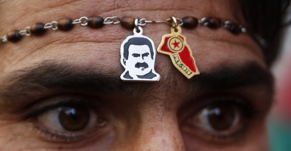 A Kurdish demonstrator wears pendants showing jailed Kurdish leader Abdullah Ocalan and a party symbol, during a protest against the operation by the Turkish army aimed at ousting the U.S.-backed Kurdish militia fromthe area of Afrin, Syria in Beirut, Lebanon, Jan. 22, 2018. (AP/Hussein Malla)