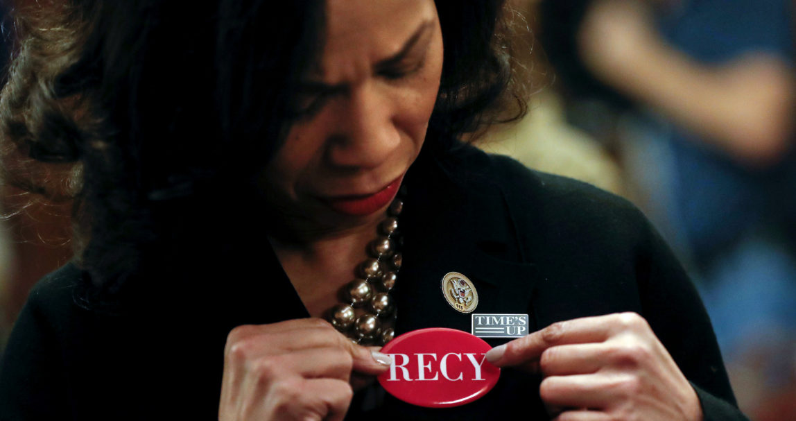 Rep. Lisa Blunt Rochester, D-Del., adjusts her 'RECY" button as she joins other House members in wearing black in support the metoo and timesup movement, ahead of tonight's State of the Union address on Capitol Hill in Washington, Tuesday, Jan. 30, 2018. Members of the Congressional Black Caucus and members of the Democratic Caucus wore red pins in memoriam of Recy Taylor. Taylor was abducted and raped while walking home from work in Alabama in 1944. (AP Photo/Pablo Martinez Monsivais)