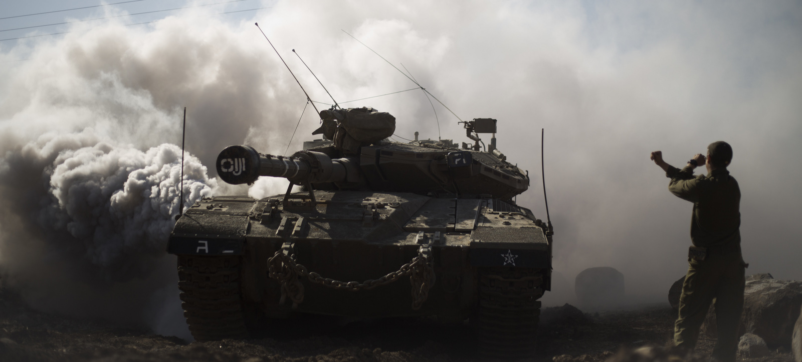 File - In this Monday, Nov. 28, 2016 file photo, Israeli soldier directs a tank near the border with Syria in the Israeli-controlled Golan Heights. A senior Israeli military officer says regional chaos has weakened the country’s enemies and created a low probability of a war in 2017 involving Israel. The official says Lebanese Hezbollah militants are mired in the Syrian civil war and the Hamas militants have lost much support from the outside. (AP Photo/Ariel Schalit, File)