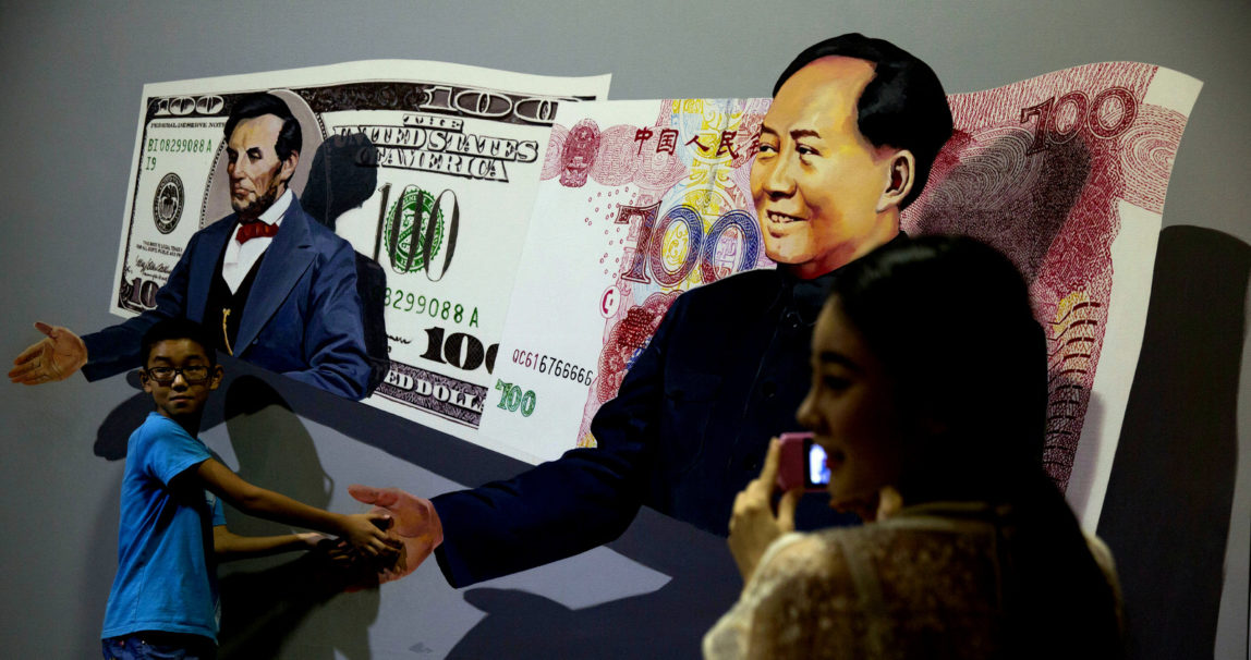 Visitors to an exhibit of art works that gives the illusion of being three dimensional pose near a scene showing late Chinese leader Mao Zedong with the Chinese yuan note and former U.S. President Abraham Lincoln with the U.S. dollar note in Beijing. (AP/Ng Han Guan)