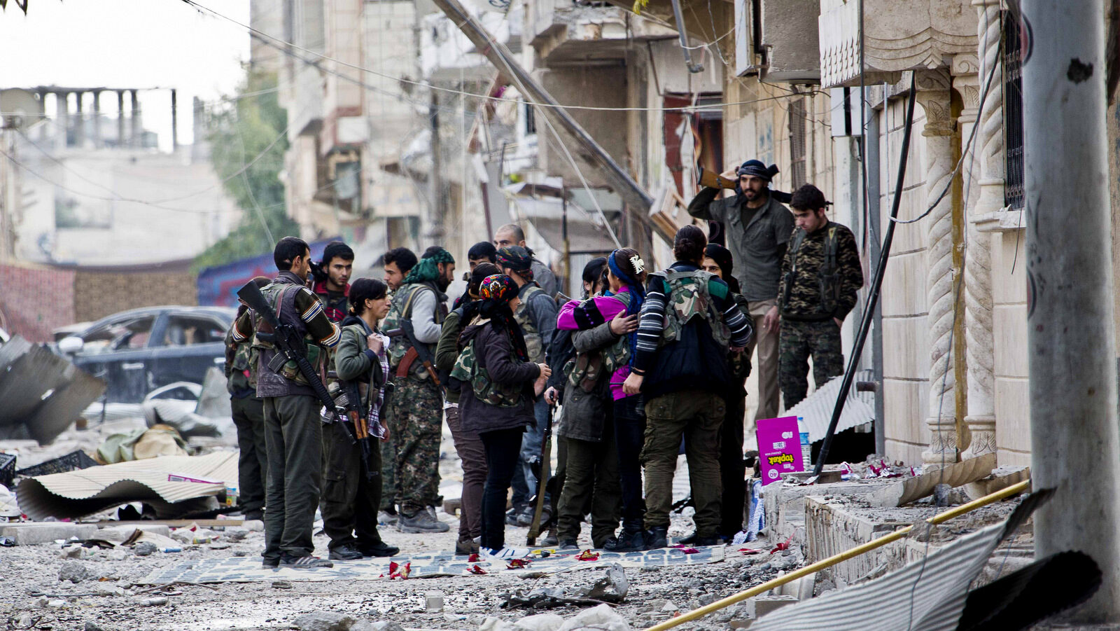 Fighters from Kurdish popular defense units YPJ (women) and YPG (men) gather during a short break before heading out to fight for new positions in Syria. According to Amnesty International, U.S.-backed Kurdish forces have forcefully displaced thousands of Syrian civilians, mostly Arabs, and demolished villages in northern Syria, often in retaliation for the residents' perceived sympathies for ISIS and other militants, Oct. 13, 2015. (AP/Jake Simkin)