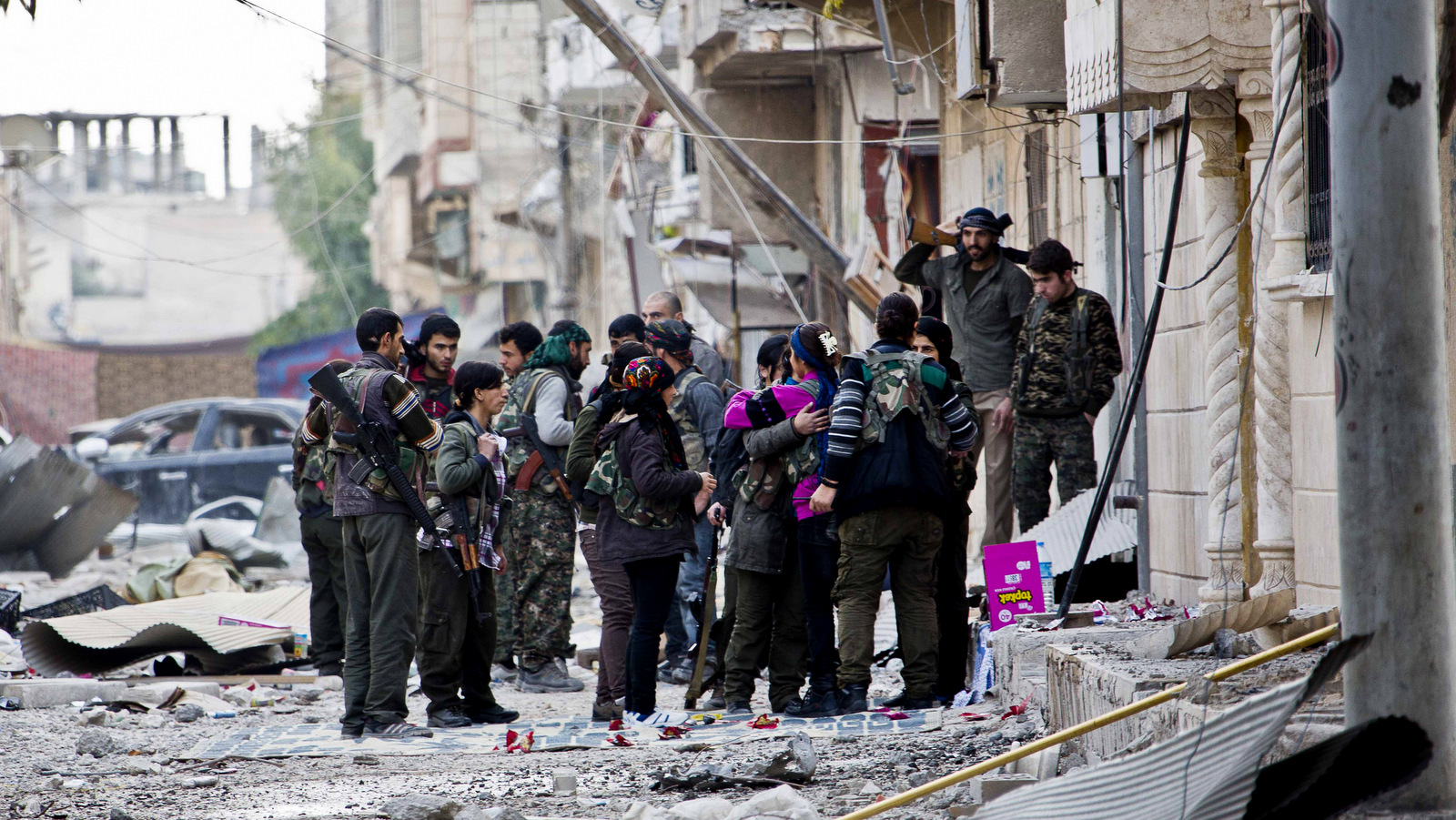 来自库尔德人民防御部队YPJ（女）和YPG（男子）的战士在短暂的休息期间聚集在一起，前往叙利亚争取新职位。根据大赦国际的说法，美国支持的库尔德部队已经迫使成千上万的叙利亚平民，主要是阿拉伯人，以及拆毁叙利亚北部的村庄，通常是为了报复居民对伊斯兰国和其他武装分子的同情，2015年10月13日。（ AP / Jake Simkin）