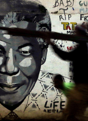 People walk past a mural of former South African President Nelson Mandela in Katlehong, south of Johannesburg, South Africa, May 11, 2015. (AP/Themba Hadebe)