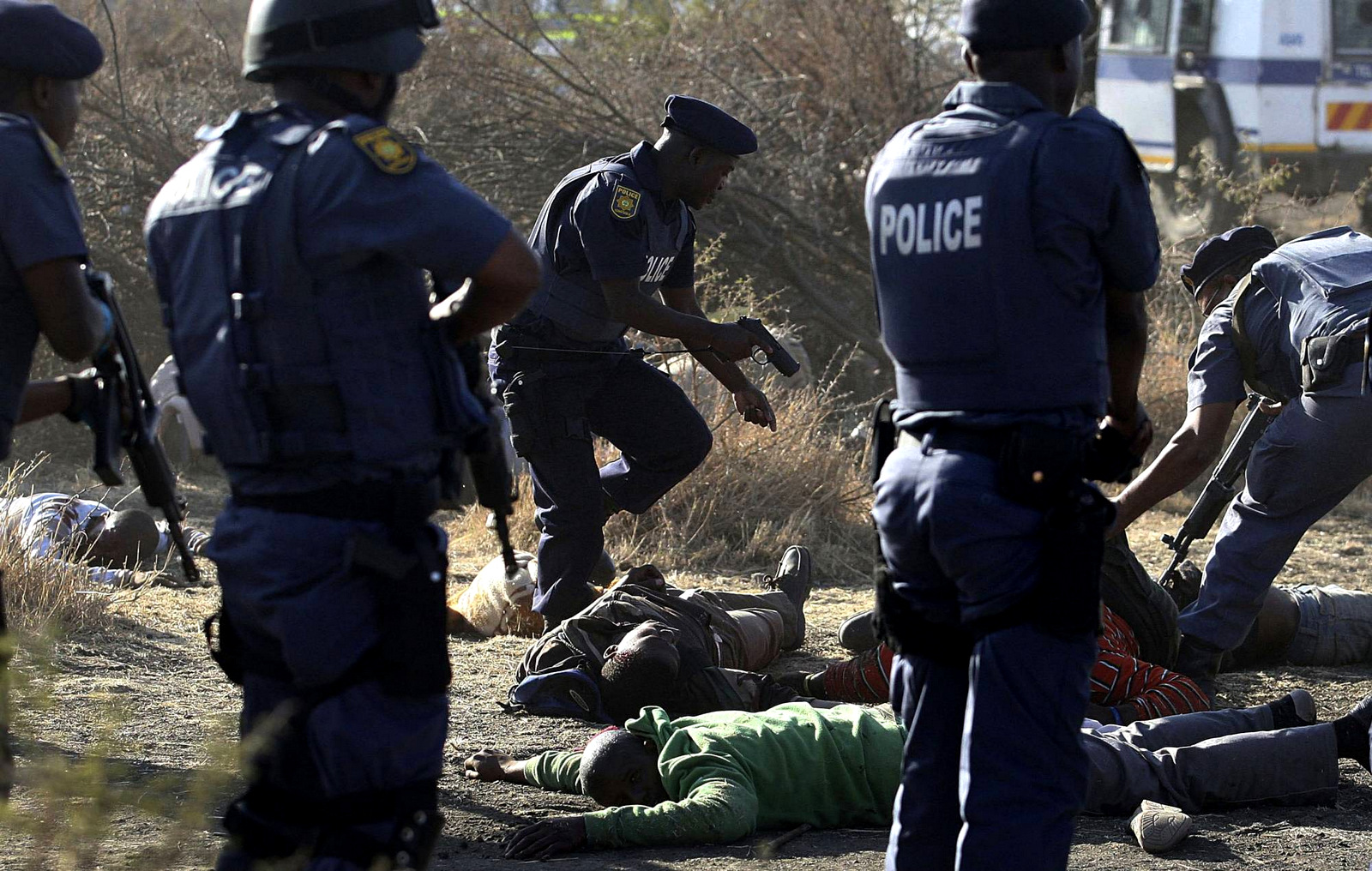 Police surround the bodies of striking miners after opening fire on a crowd at the Lonmin Platinum Mine in Marikana, near Rustenburg, South Africa killing 34. More than five years after the event rights groups say no one has been prosecuted and miners' living conditions are as "squalid" as ever,Aug. 16, 2012. (AP Photo)