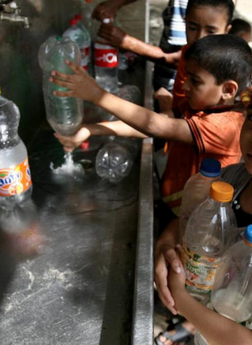 Palestinian children fill their bottles with water from a UNICEF tap in Rafah in the southern Gaza Strip. (Photo: UNICEF)