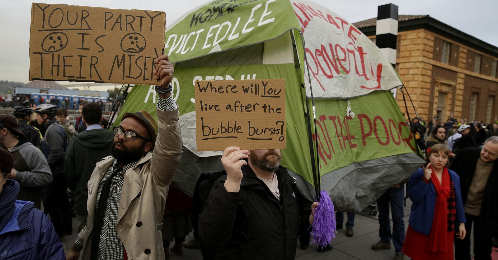In this Feb. 3, 2016 photo, people hold up signs and a tent during a protest to demand city officials do more to help homeless people. (AP/Eric Risberg)