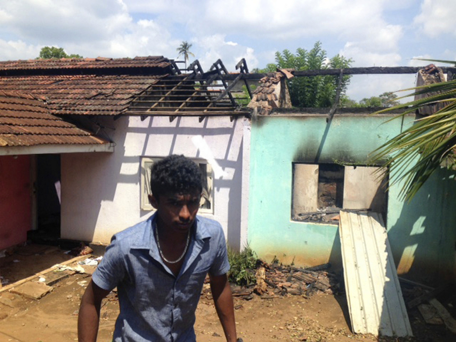 A Sri Lankan walks past a burnt house in Pallekele, Sri Lanka, March 8, 2018. (AP/Bharatha Mallawarachchi)