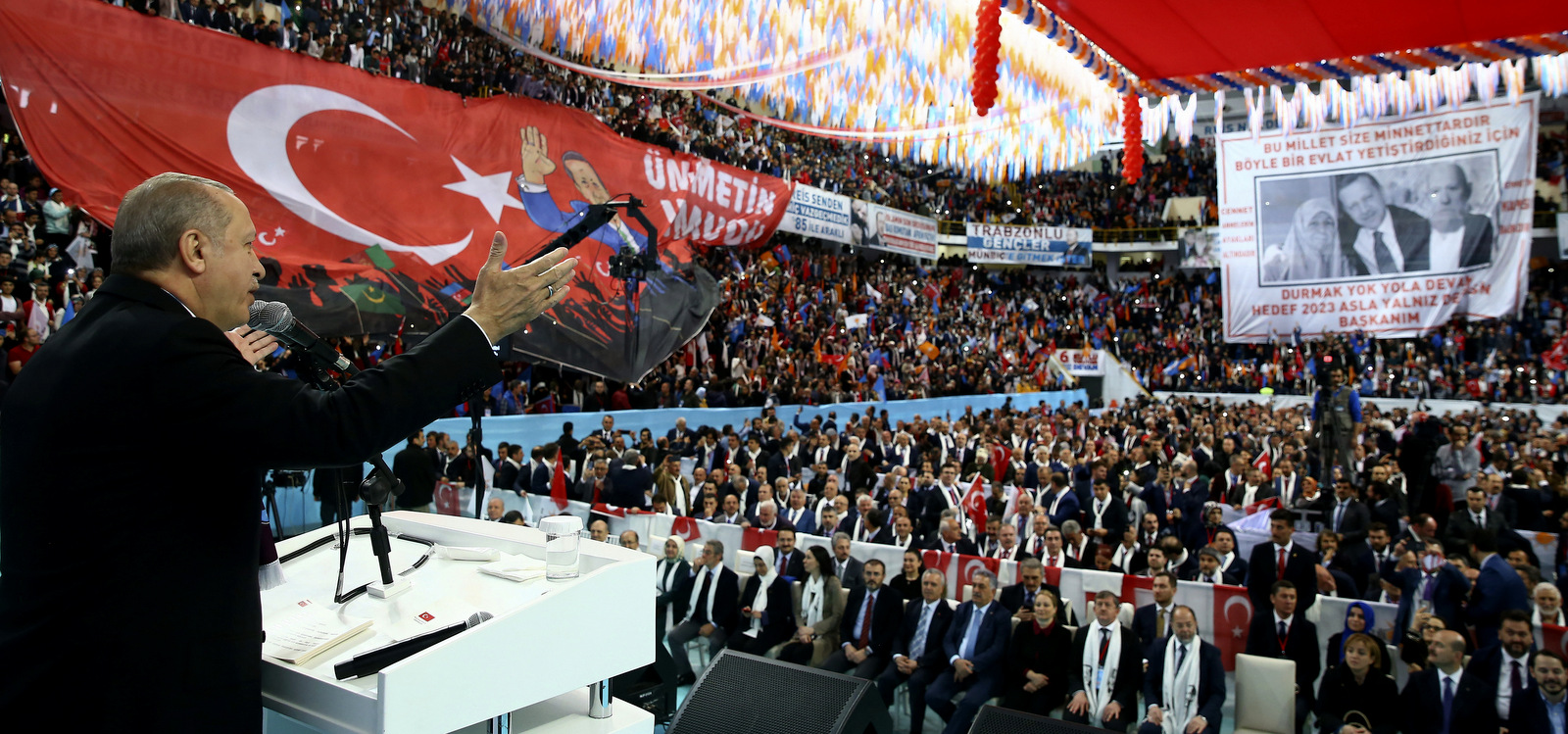 Turkey's President Recep Tayyip Erdogan addresses the members of his ruling party in Trabzon, Turkey, Sunday, March 25, 2018. Erdogan has announced the country is conducting operations in northern Iraq against Kurdish rebels it deems "terrorists." Erdogan on Sunday said "operations" have begun in Sinjar to clear the mountainous area of Kurdistan Workers' Party, or PKK, fighters. An image showing him with his parents Tenzile, left, and Ahmet Erdogan is in the background. (Kayhan Ozer/Pool Photo via AP)