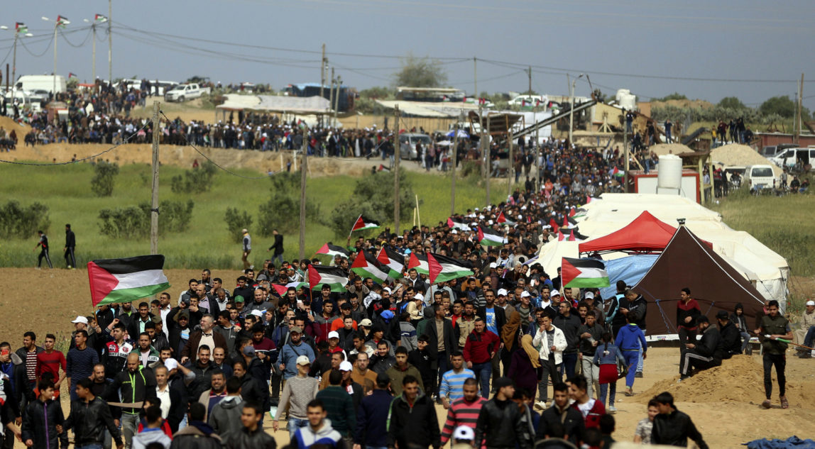 Palestinians attend a demonstration near the Gaza Strip border with Israel in eastern Gaza City, Friday, March 30, 2018. (AP/ Khalil Hamra)