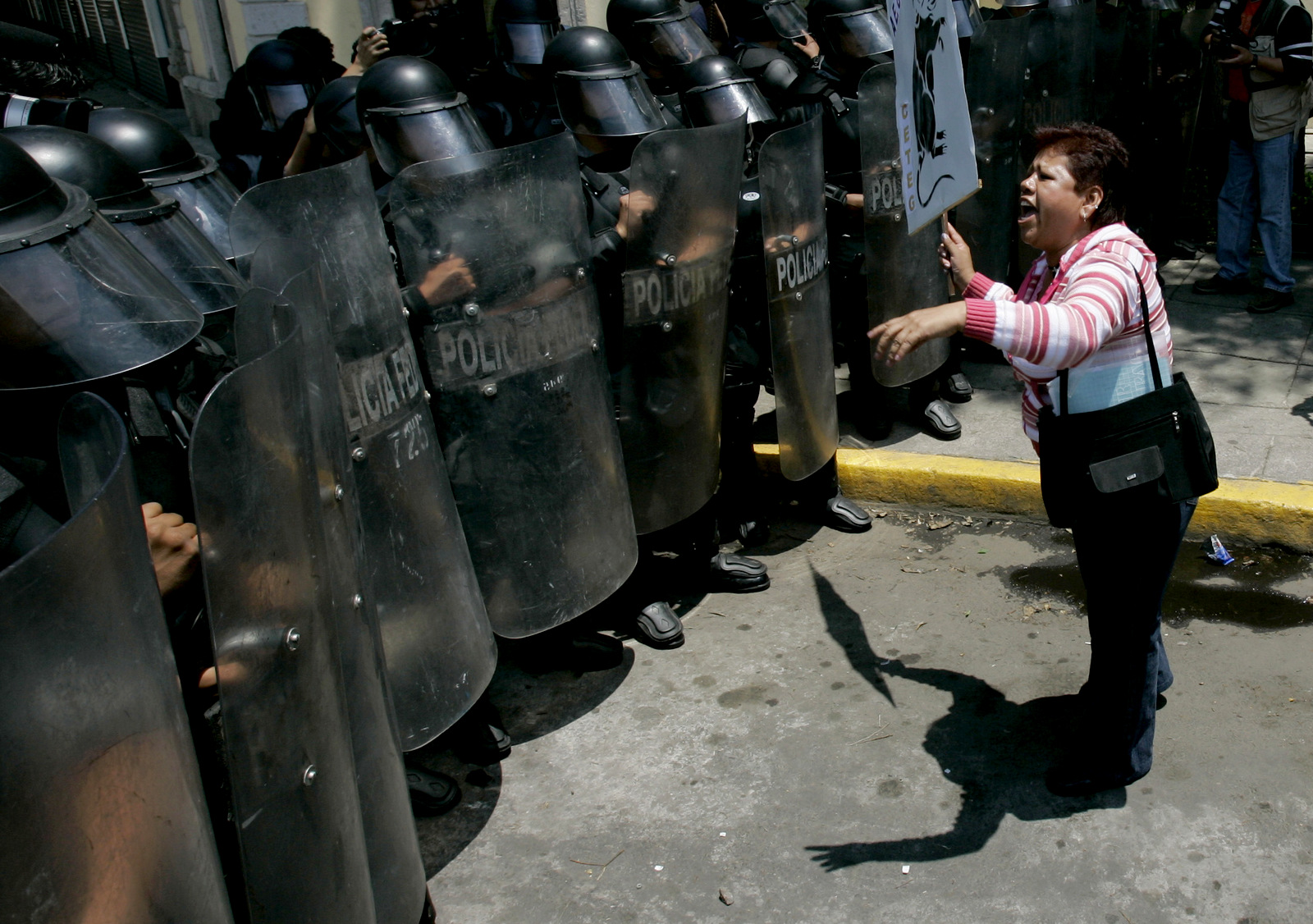 A woman confronts riot police during a protests on May 19, 2006 following a violent crackdown by police in the town of San Salvador Atenco. (AP/Eduardo Verdugo)