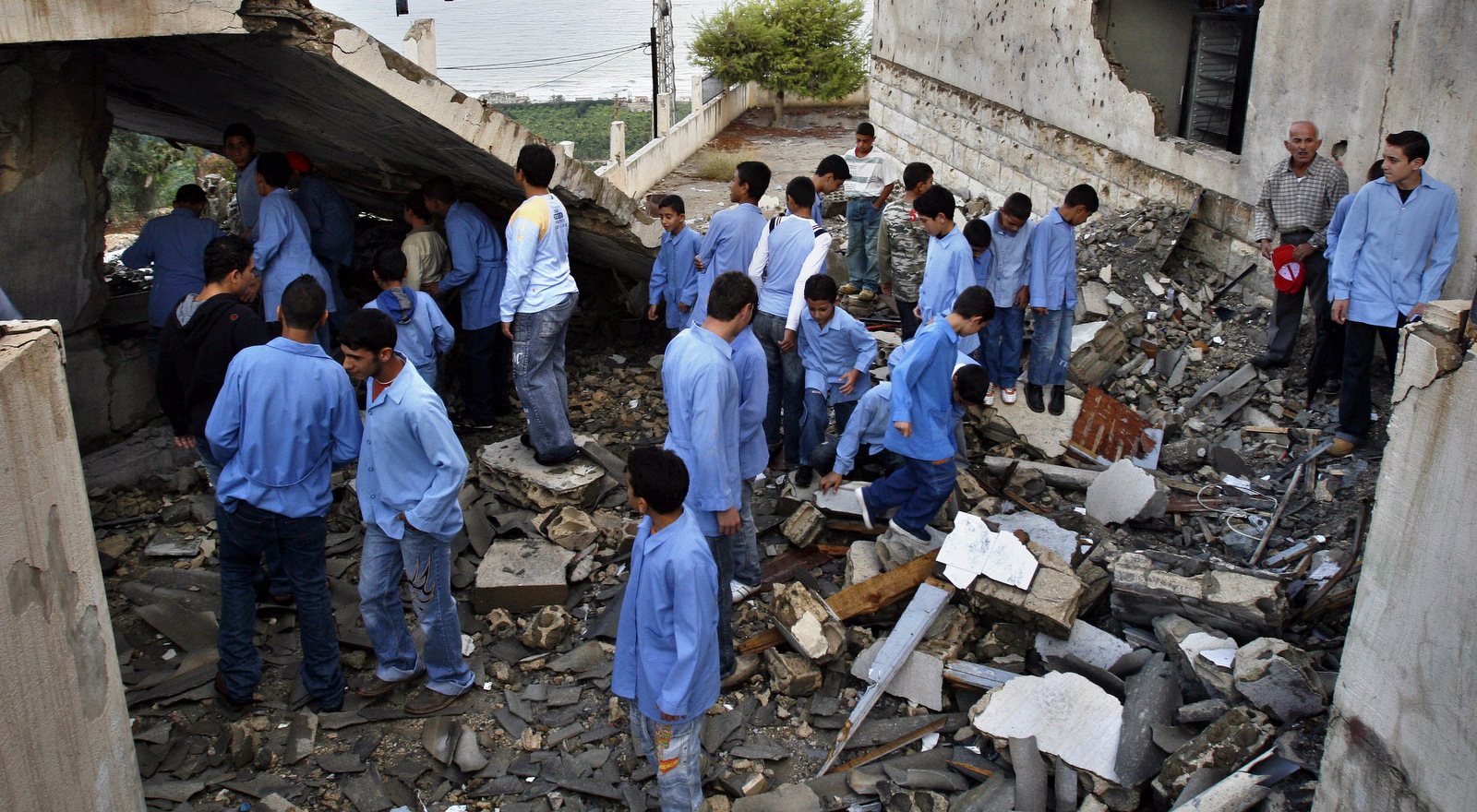 Lebanese students stand in the Ansarieh Public School that was destroyed during Israel's attack on Lebanon, in the southern village of Ansarieh, Oct. 16, 2006. (AP/Mohammed Zaatari)