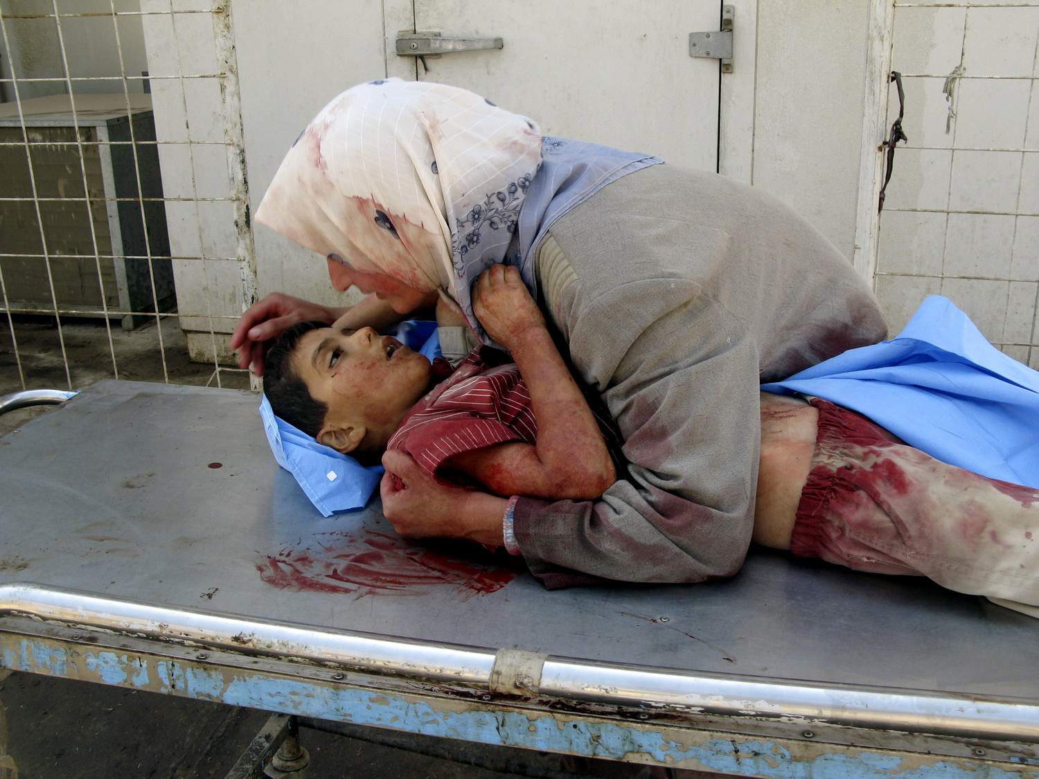 A woman takes her dead son into her arms, as she grieves for her six-year-old son, Dhiya Thamer, who was killed when their family car came under fire by unknown gunmen in Baqouba, Iraq, Sept. 16, 2007. (AP/Adem Hadei)