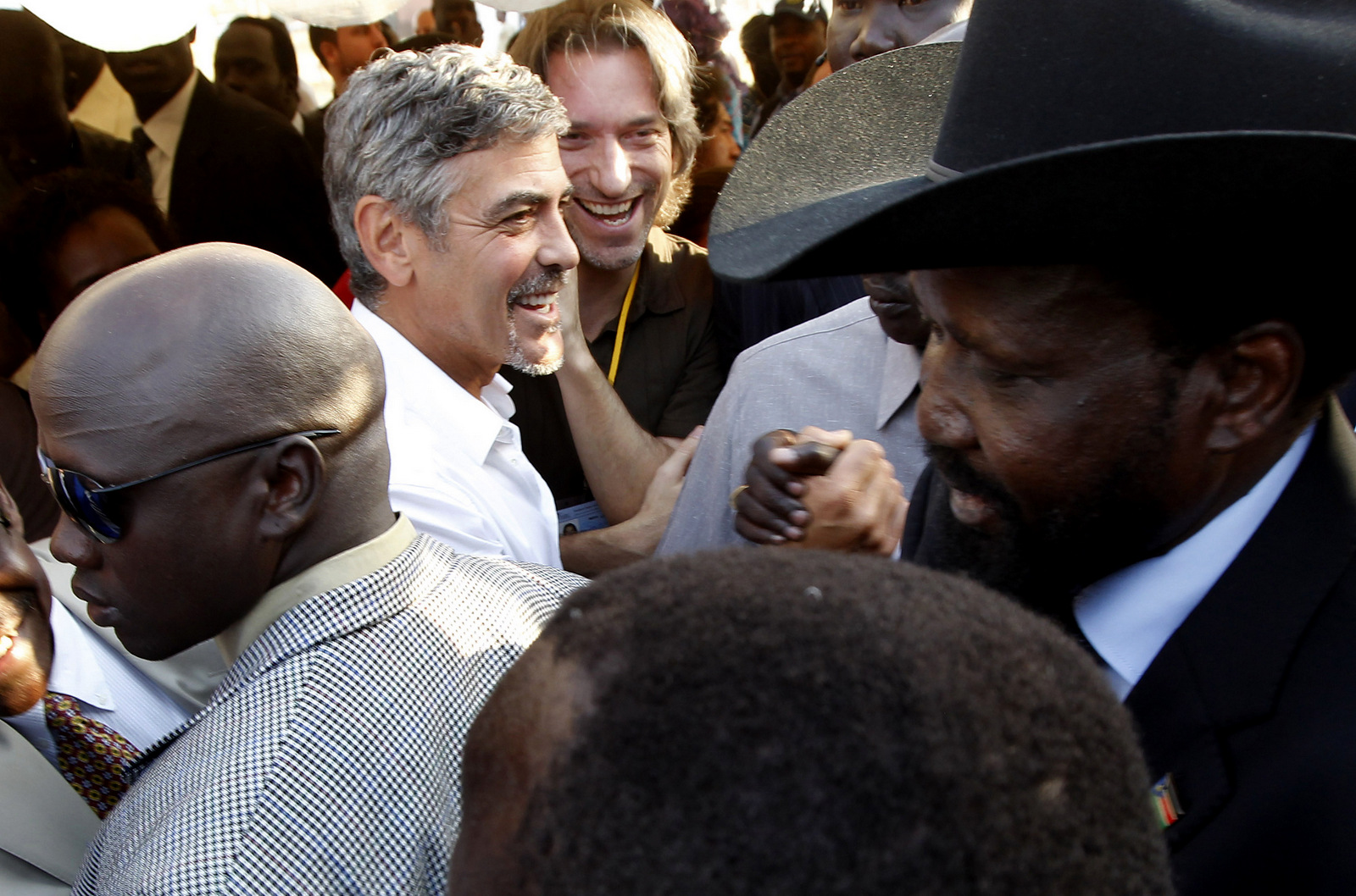 George Clooney smiles as Southern Sudan President Salva Kiir walks past after casting his vote in front of a cheering crowd of hundreds of Sudanese voters in Juba, Southern Sudan, Jan. 9, 2011. (AP/Jerome Delay)