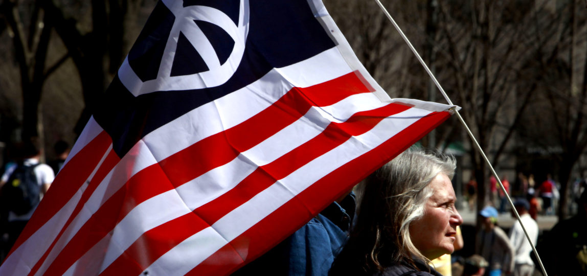 Peace activist Marilyn Cornell, of Strongsville, Ohio, holds an American flag with a peace sign on it during an anti-war protest in Washington, on March 20, 2010, where thousands of protesters marched through Washington to protest the wars in Iraq and Afghanistan on the seventh anniversary of the invasion of Iraq. (AP/Jacquelyn Martin)