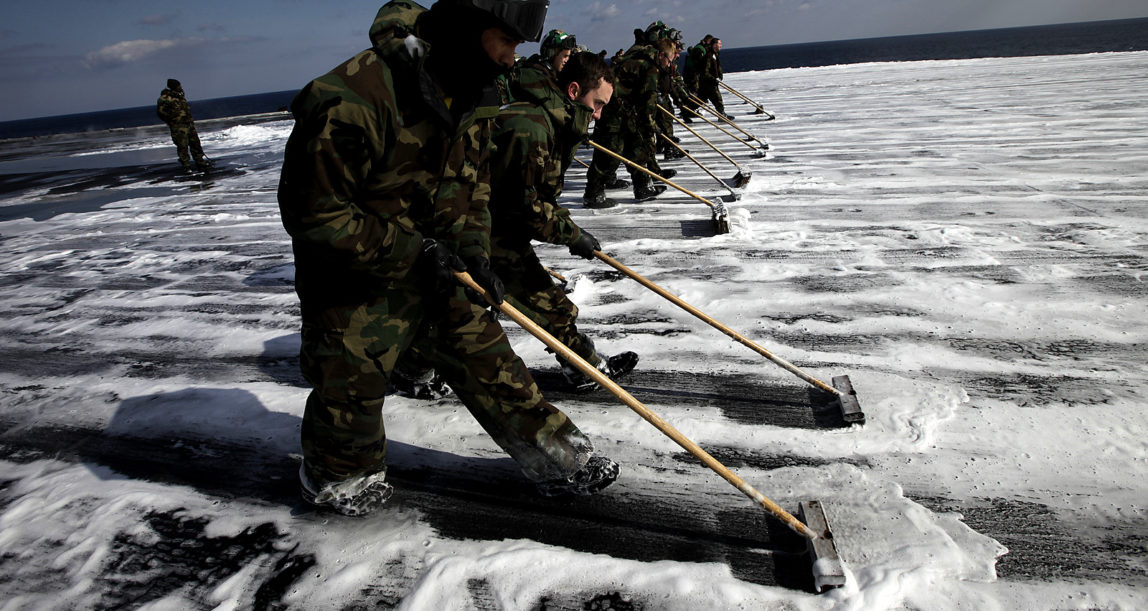 U.S. Navy crew members mop up the flight deck to remove radioactive contamination from the aircraft carrier USS Ronald Reagan (CVN76), March 23, 2011 in the Pacific Ocean off the Japanese coast after 10 days of rescue missions to transport supplies to survivors in an earthquake- and tsunami-devastated area. (AP/Eugene Hoshiko)