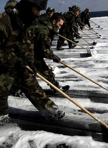 U.S. Navy crew members mop up the flight deck to remove radioactive contamination from the aircraft carrier USS Ronald Reagan (CVN76), March 23, 2011 in the Pacific Ocean off the Japanese coast after 10 days of rescue missions to transport supplies to survivors in an earthquake- and tsunami-devastated area. (AP/Eugene Hoshiko)