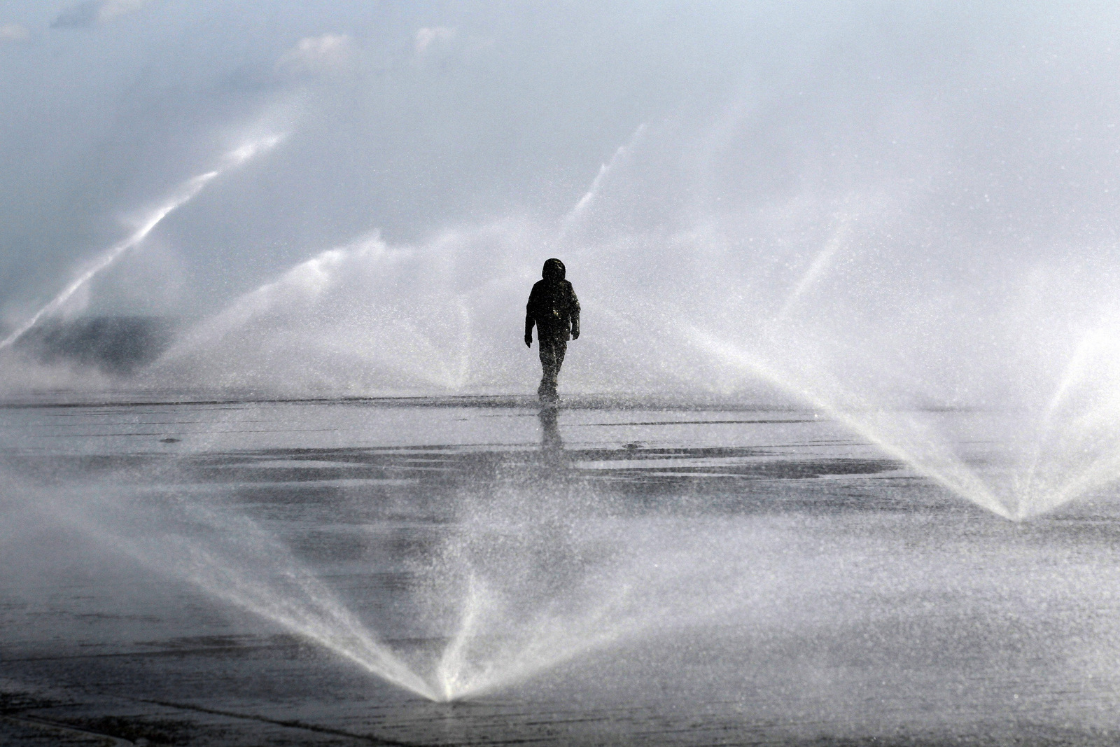 A flight deck crew walk on the flight deck where water is sprayed for radioactive decontamination aboard the aircraft carrier USS Ronald Reagan (CVN76) in the Pacific Ocean off the Japanese coast, March 23, 2011. (AP/Eugene Hoshiko)