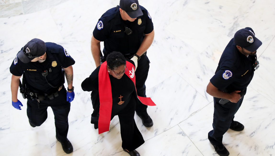 A minister belonging to a group demanding Congress reject the Trump administration's budget proposals and health care bill, is arrested during a demonstration in the Russell Senate Building on Capitol Hill in Washington, July 18, 2017. (AP/Manuel Balce Ceneta)
