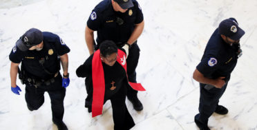 A minister belonging to a group demanding Congress reject the Trump administration's budget proposals and health care bill, is arrested during a demonstration in the Russell Senate Building on Capitol Hill in Washington, July 18, 2017. (AP/Manuel Balce Ceneta)