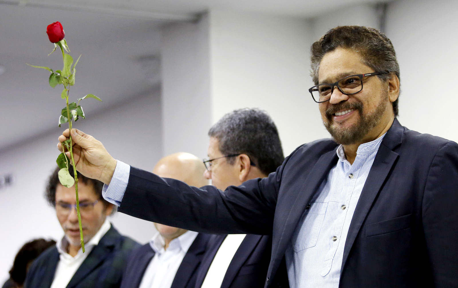 Ivan Marquez holds a red rose, the symbol of the new political party Alternative Communal Revolutionary Forces, during a press conference in Bogota, Colombia, Sept. 1, 2017. (AP/Fernando Vergara)
