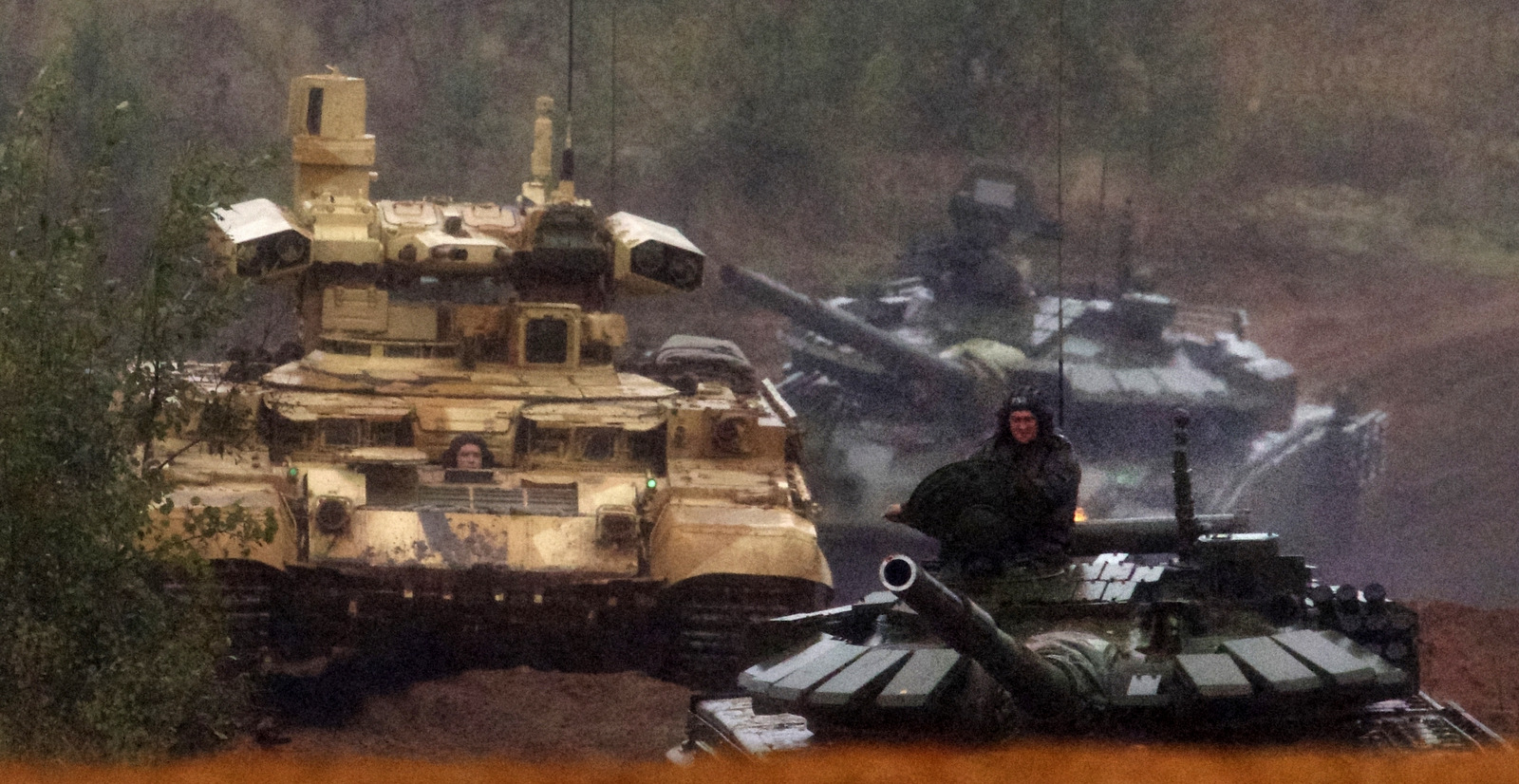 A Russian military combat vehicle, left, and tanks roll during a military exercise at a training ground at the Luzhsky Range, near St. Petersburg, Russia, Sept. 18, 2017. The Zapad (West) 2017 maneuvers have caused concern among some NATO members neighboring Russia, who have criticized a lack of transparency about the exercises and questioned Moscow's real intentions. (AP/Ivan Sekretarev)