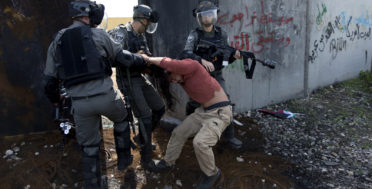 Israeli border police drag an activist by the next to Israel's apartheid wall during a protest in the occupied West Bank village of Bil'in, west of Ramallah, March 2, 2018. Palestinian protesters and foreign activists marched to commemorate the 13th anniversary of the ongoing weekly protests against the Israeli apartheid wall and Jewish-only settlements in Bil'in. (AP/Nasser Nasser)Israeli border police drag an activist by the next to Israel's apartheid wall during a protest in the occupied West Bank village of Bil'in, west of Ramallah, March 2, 2018. Palestinian protesters and foreign activists marched to commemorate the 13th anniversary of the ongoing weekly protests against the Israeli apartheid wall and Jewish-only settlements in Bil'in. (AP/Nasser Nasser)