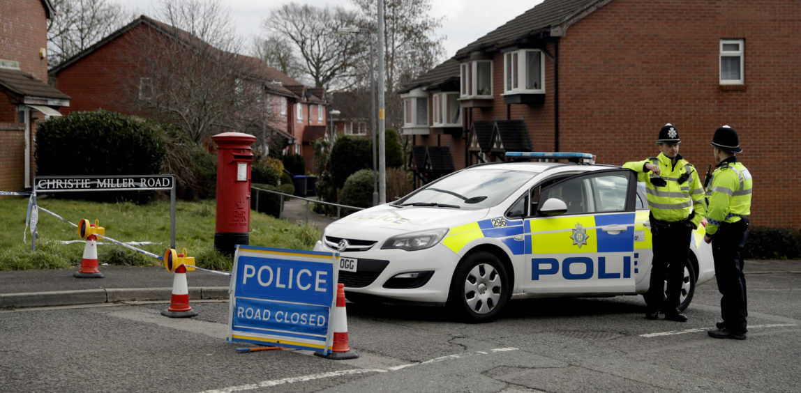 Police officers stand guard at the bottom of the road where former Russian double agent Sergei Skripal lives in Salisbury, England, Tuesday, March 13, 2018. The use of Russian-developed nerve agent Novichok to poison ex-spy Sergei Skripal and his daughter makes it "highly likely" that Russia was involved, British Prime Minister Theresa May said Monday. Novichok refers to a class of nerve agents developed in the Soviet Union near the end of the Cold War. (AP Photo/Matt Dunham)