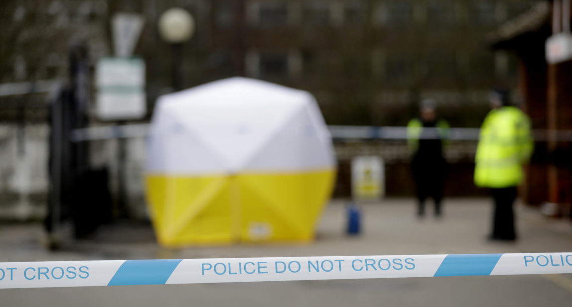 Police officers guard a cordon around a police tent covering a supermarket car park pay machine near the spot where former Russian double agent Sergei Skripal and his daughter were found critically ill following exposure to the Russian-developed nerve agent Novichok in Salisbury, England, Tuesday, March 13, 2018. The use of Russian-developed nerve agent Novichok to poison ex-spy Sergei Skripal and his daughter makes it "highly likely" that Russia was involved, British Prime Minister Theresa May said Monday. Novichok refers to a class of nerve agents developed in the Soviet Union near the end of the Cold War. (AP Photo/Matt Dunham)