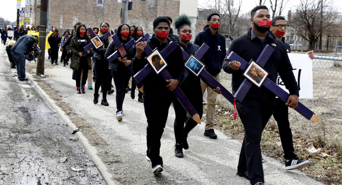 High school senior D'Angelo McDade, front right, leads a march in Chicago's North Lawndale neighborhood during a walkout to protest gun violence, March 14, 2018. About 200 students joined the march as a sign of solidarity with students at Marjory Stoneman Douglas High School in Parkland, Fla., the scene of a recent school shooting in Florida in which 17 students and educators died. (AP/Martha Irvine)