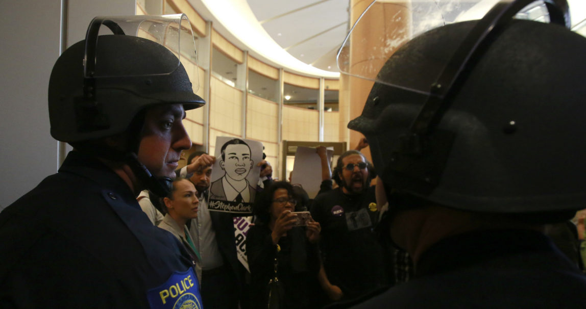 Helmeted Sacramento Police officers block the entrance to the Sacramento City Council chambers from demonstrators protesting the shooting death of Stephon Clark by Sacramento Police, Tuesday, March 27, 2018, in Sacramento, Calif. Clark, who was unarmed, was shot and killed a week earlier by two officers responding to a call about a person smashing car windows. (AP Photo/Rich Pedroncelli)