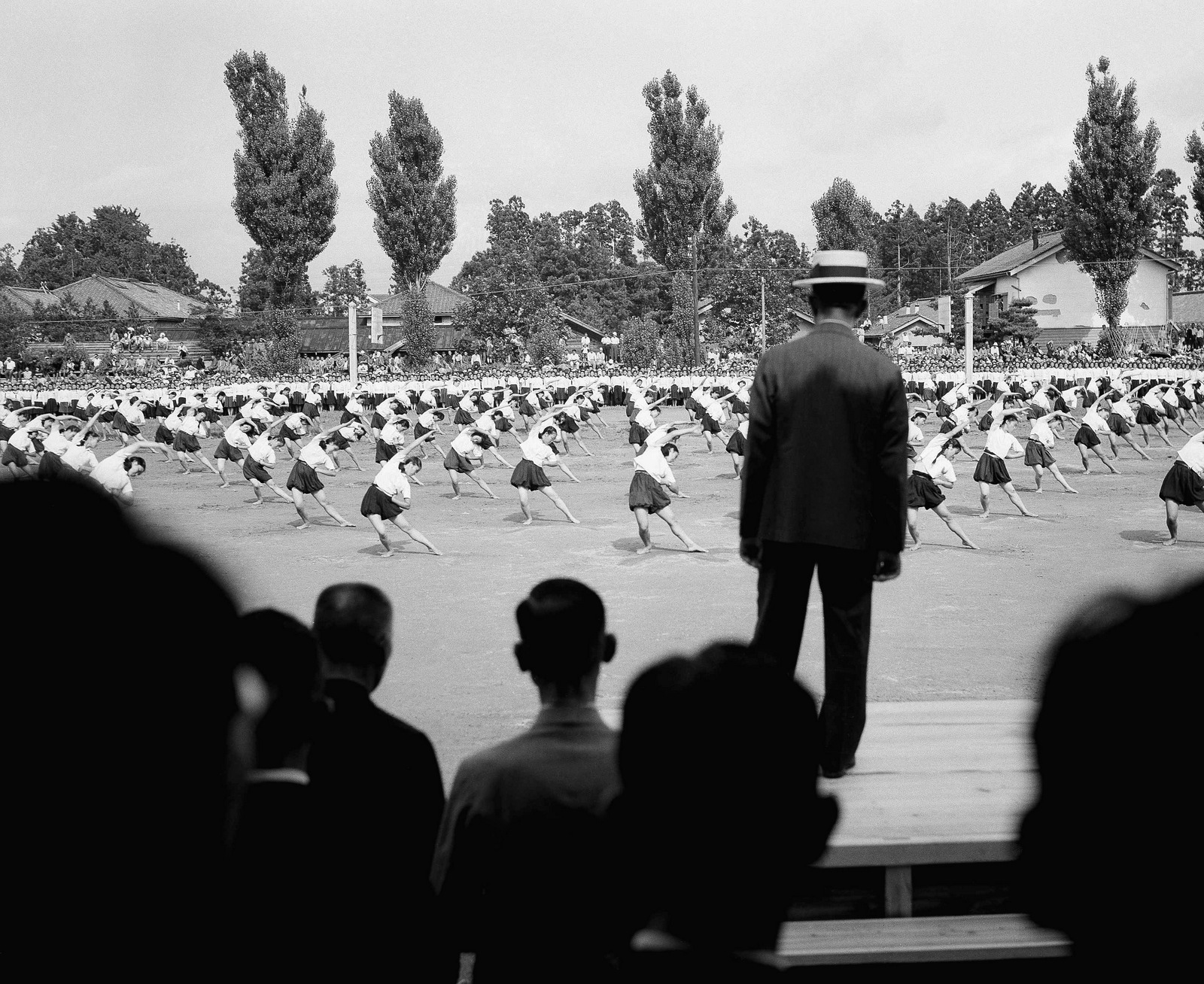 School girls at the Iwate prefecture school go through their calisthenic exercises for the Emperor Hirohito (back to camera) in Japan on August 10, 1947. (AP/Charles P. Gorry)