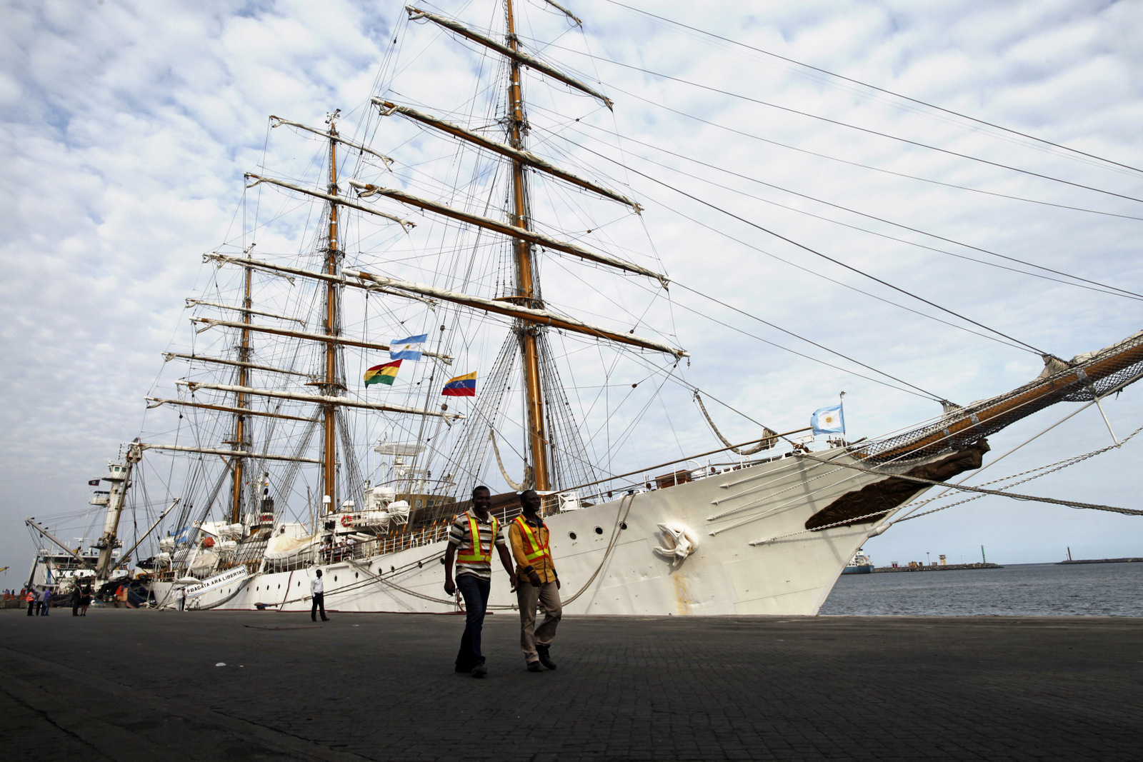 Port workers walk past the three-masted ARA Libertad, a symbol of Argentina's navy, as it lies docked at the port in Tema, outside Accra, Ghana, Oct. 23, 2012. (AP/Gabriela Barnuevo)