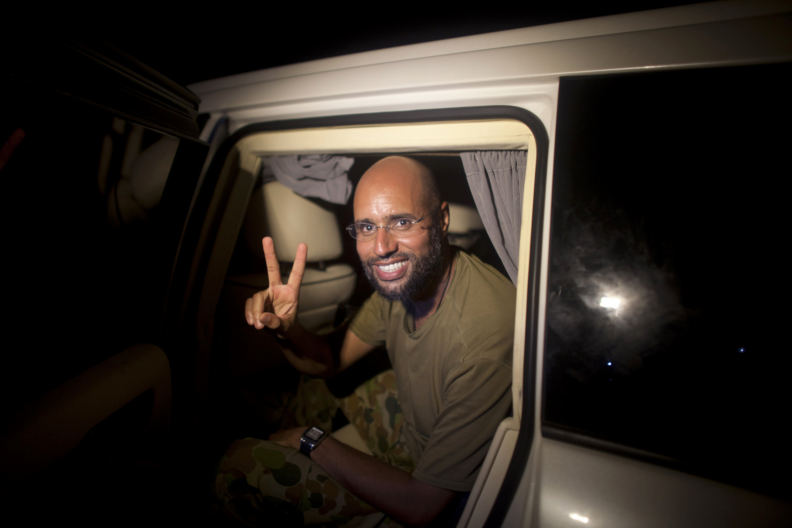 Saif al-Islam makes a victory sign as he appears at the Rixos hotel in Tripoli, Libya, Aug. 23, 2011. (AP/Dario Lopez-Mills)