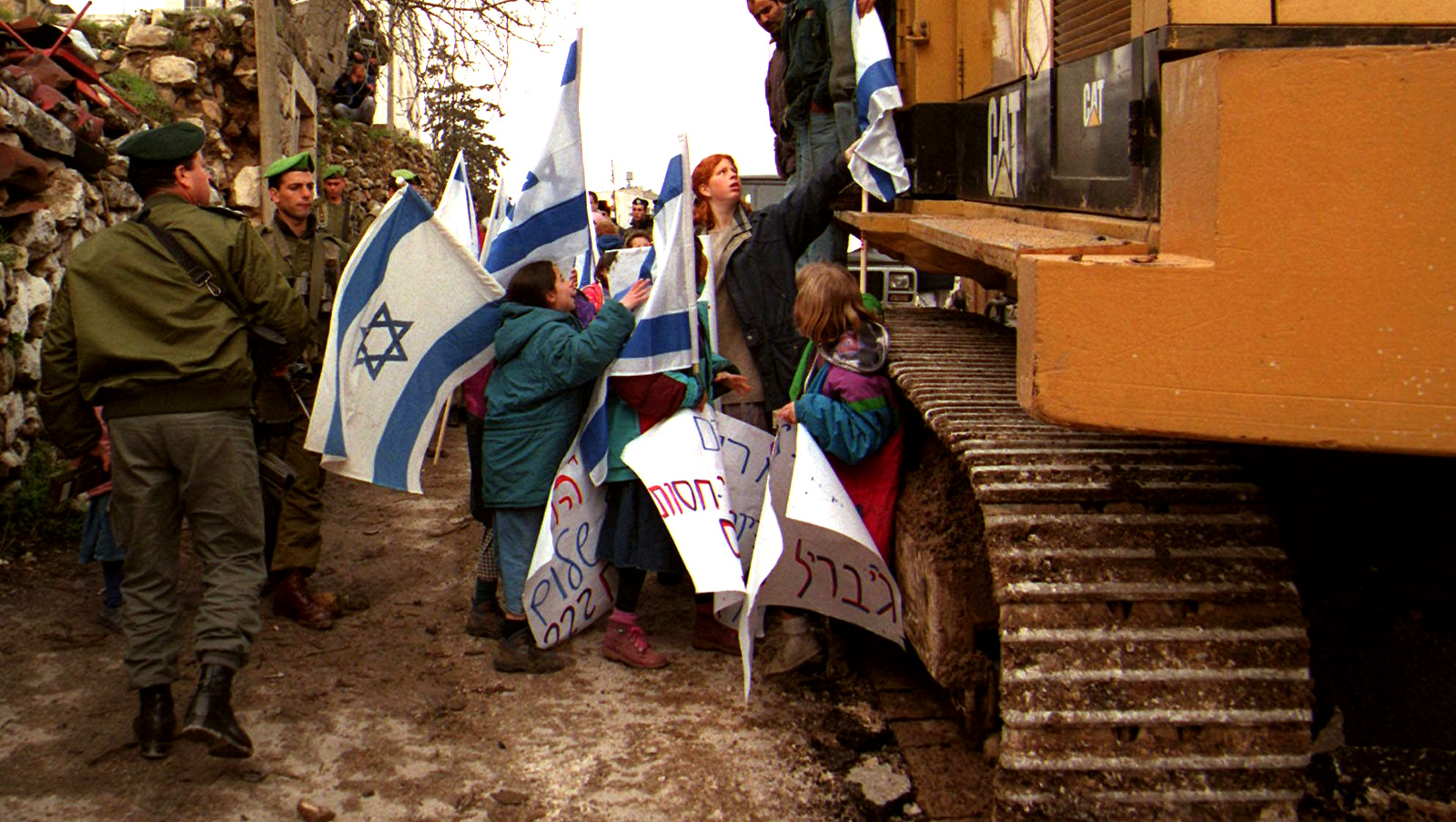 Los colonos israelíes intentan detener a los trabajadores palestinos en una excavadora en Hebrón, preparando el trabajo para una nueva fundación en la calle Shuhada, 18 de marzo de 1997. (AP / Nasser Shiyoukhi)