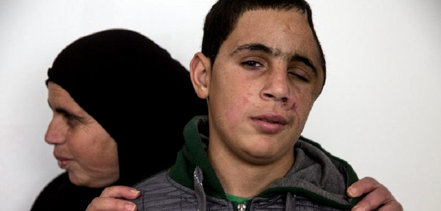 Mohammad Tamimi, 15, with his mother, at his home in the occupied West Bank village of Nabi Salah on 13 January.(Photo: Heidi Levine/Sipa Press)