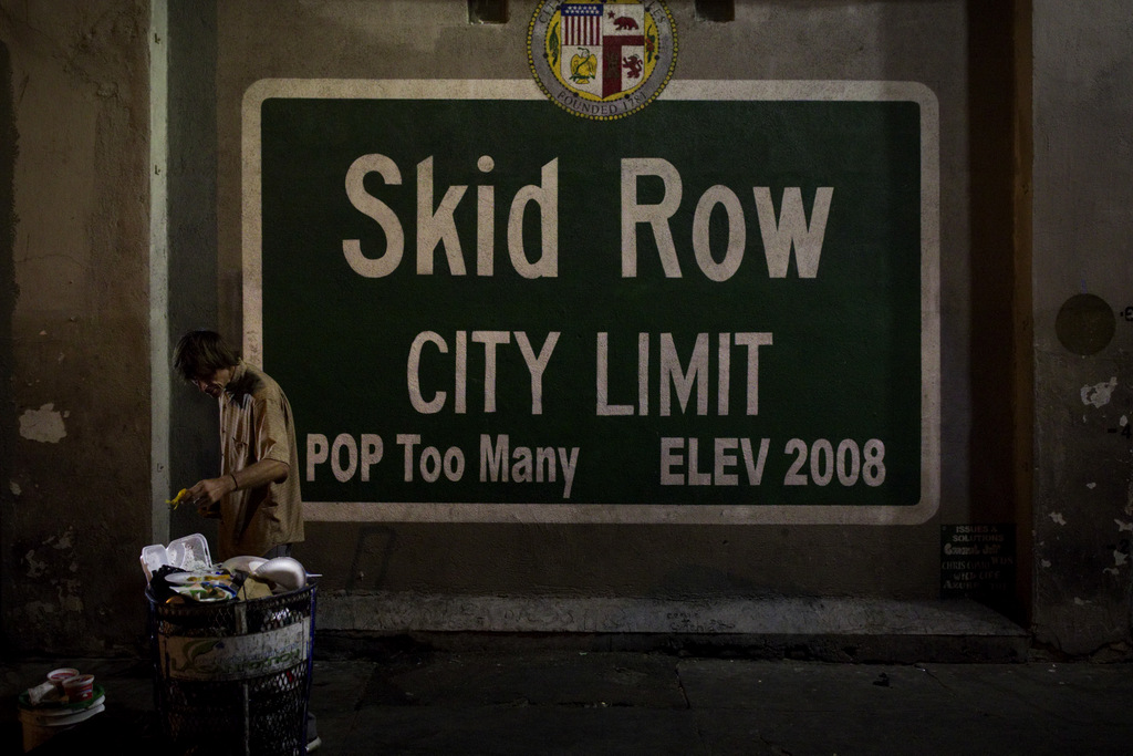 A homeless man takes food from a trash can in Los Angeles' Skid Row area, home to the nation's largest concentration of homeless people, Oct. 28, 2017, in Los Angeles. At least 10 cities have declared official states of emergency, and California declared a statewide emergency due to a hepatitis A outbreak linked to homeless encampments. Comparisons are being made to conditions more commonly seen in Third World countries. (AP/Jae C. Hong)