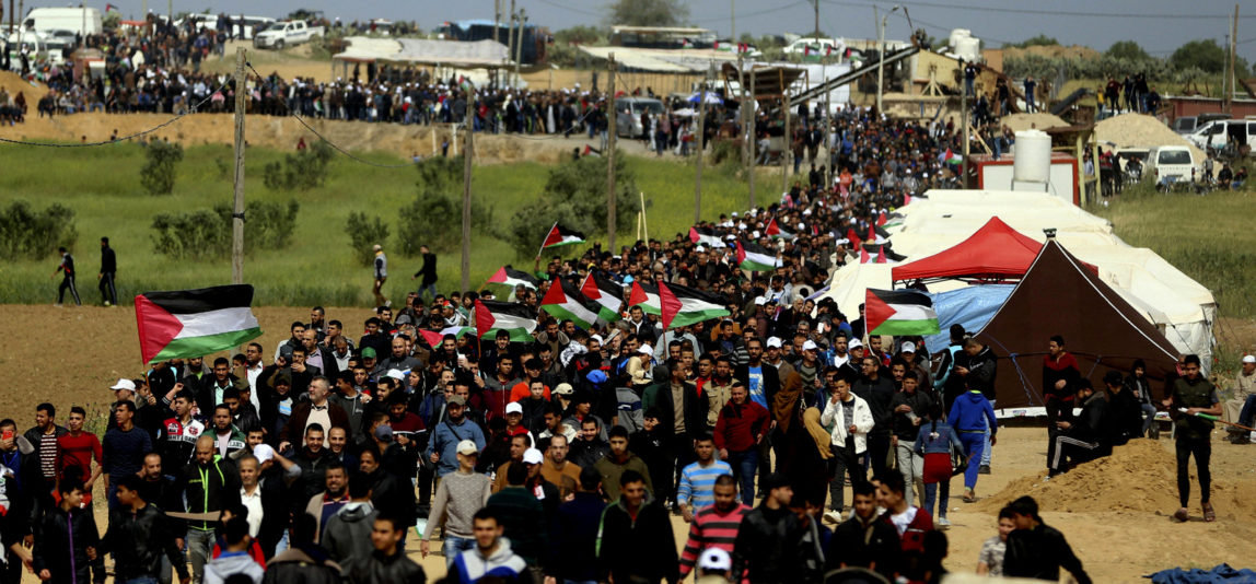 Palestinians attend a demonstration near the Gaza Strip border with Israel in eastern Gaza City, Friday, March 30, 2018. (AP Photo/ Khalil Hamra)