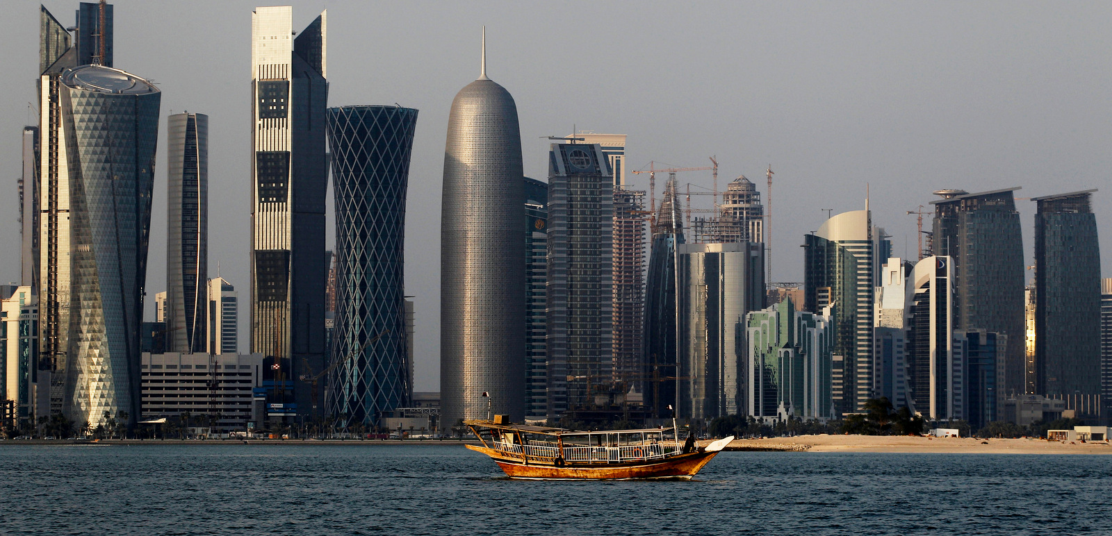 A traditional dhow floats in the Corniche Bay of Doha, Qatar. Saudi media reported, April 9, 2018, a proposal to dig a maritime canal along the kingdom's closed border with Qatar, turning the peninsula-nation into an island and further isolating it. Saudi Arabia's state-linked Sabq and al-Riyadh newspapers carried nearly identical reports on Monday saying that the so-called Salwa Marine Canal project would be funded by Saudi and Emirati investors and carried out by Egyptian developers. (AP/Saurabh Das)
